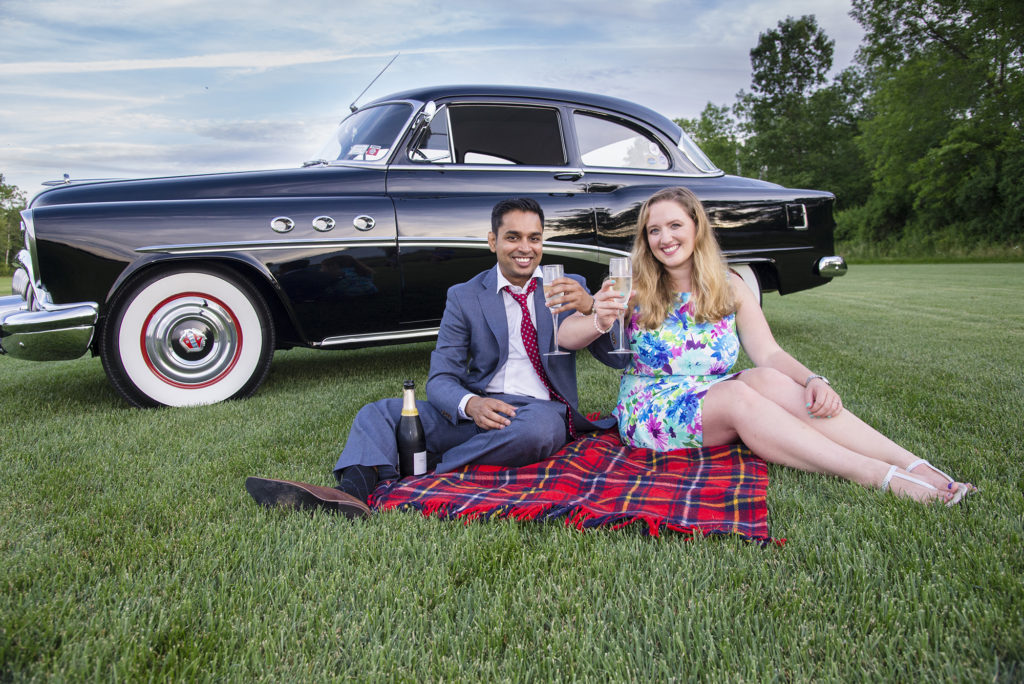 couple toasting by antique car