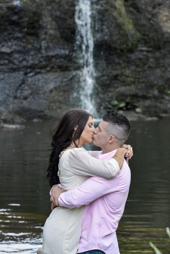 couple kissing by waterfall