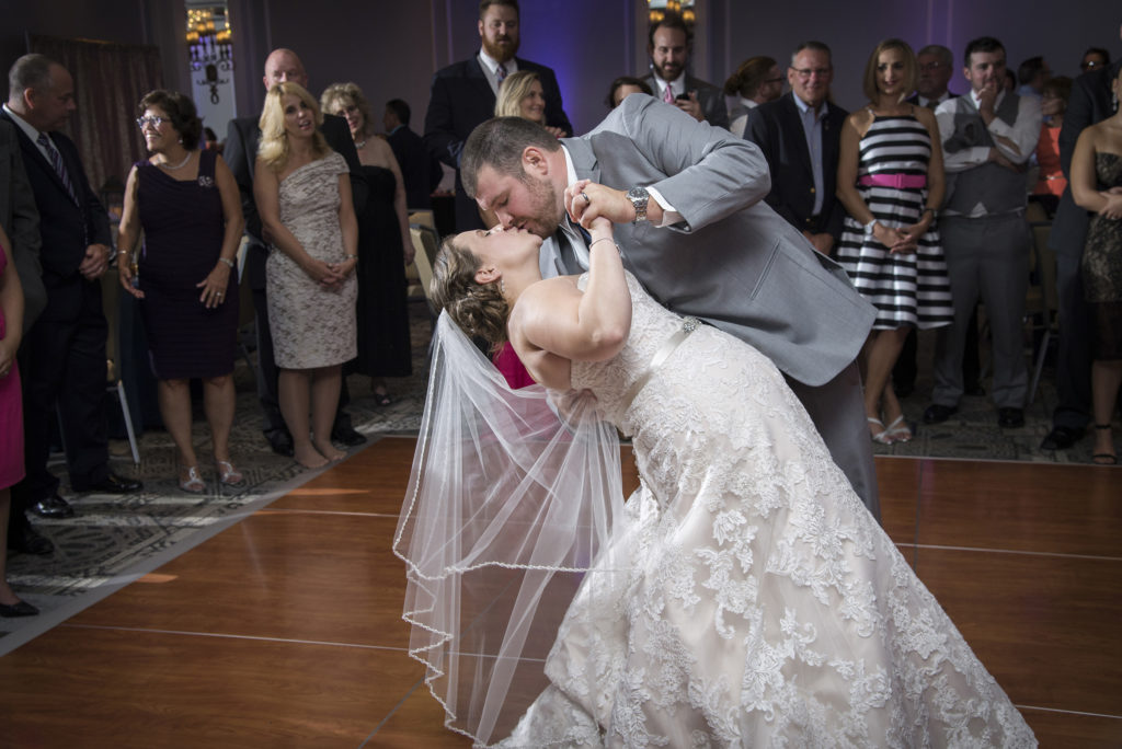 photographer bride and groom kissing during first dance as guests watch